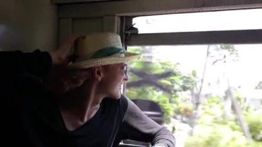 Genç ve neşeli bir adam Sri Lanka'da trenle seyahat ediyor.. 