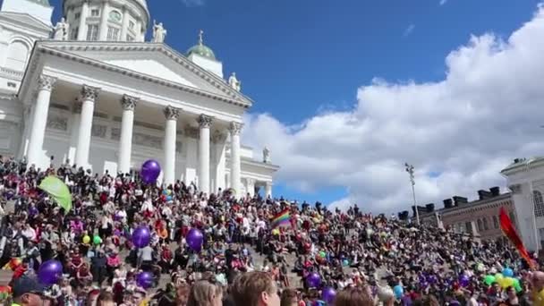 ヘルシンキ フィンランド 2018 ゲイプライドパレード中にヘルシンキの上院広場で虹の旗と気球を持つ人々 — ストック動画