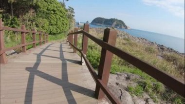 Jeju adasının parkında güzel bir yürüyüş ahşap iz, Gün batımında Kore.