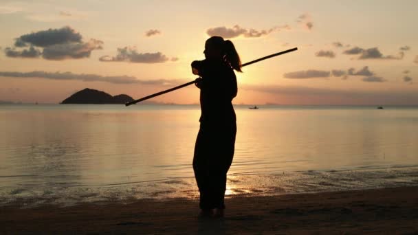 Silhouette Young Powerful Woman Beach Doing Kung Exercises Stick Background — Stock Video