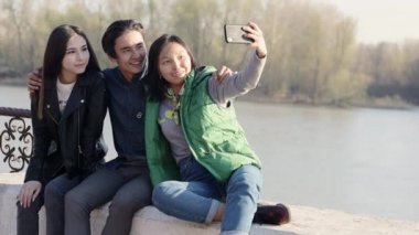 Üç güzel Asyalı gençler akıllı telefon ile komik bir selfie alarak.