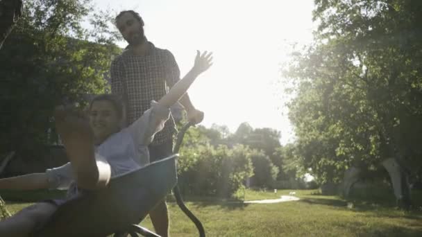 Young happy couple having fun and riding a country trolley. — Stock Video