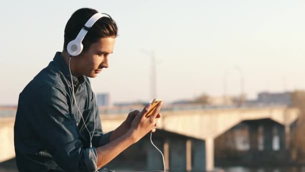 Asiática mestiza morena adolescente escuchando música con sus auriculares — Vídeos de Stock
