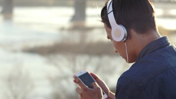 Imágenes de primer plano de un adolescente escuchando música con sus auriculares — Vídeos de Stock