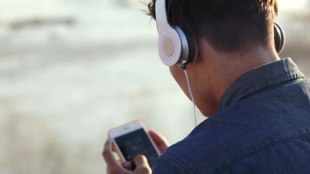 Крупним планом кадри хлопчика-підлітка, що слухає музику з навушниками — стокове відео