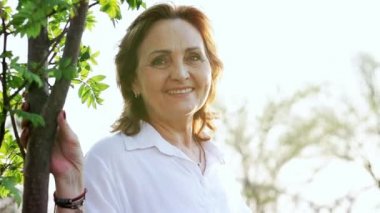 Güzel mutlu yaşlı kadın yaz parkında iyi vakit geçiriyor.