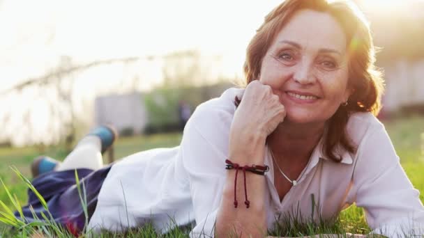 Vacker lycklig äldre kvinna som har en bra tid på sommar parken. — Stockvideo