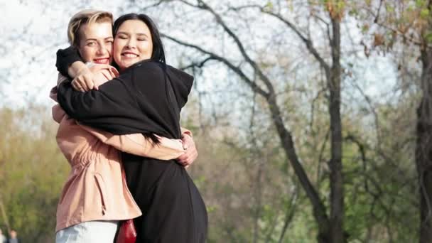 Dos mujeres jóvenes diferentes nacionalidades amigos cercanos abrazándose — Vídeo de stock
