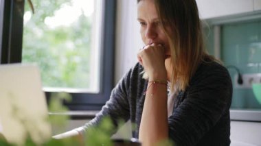 Genç kadın serbest bir dizüstü bilgisayarda e-posta yazarak evden serbest çalışan