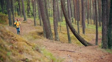 Ormanda yürüyen turist sırt çantası olan mutlu bir kadın.