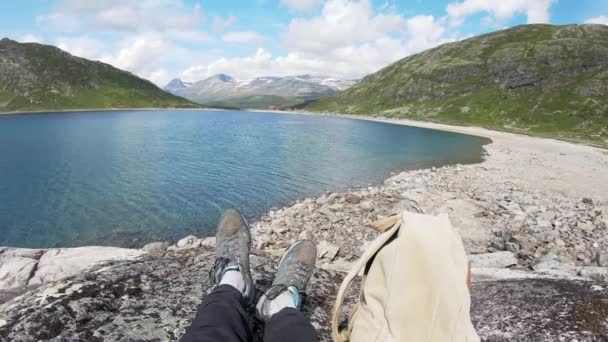 Egyedül üldögél a sziklán egy norvég fjord felett.. — Stock videók