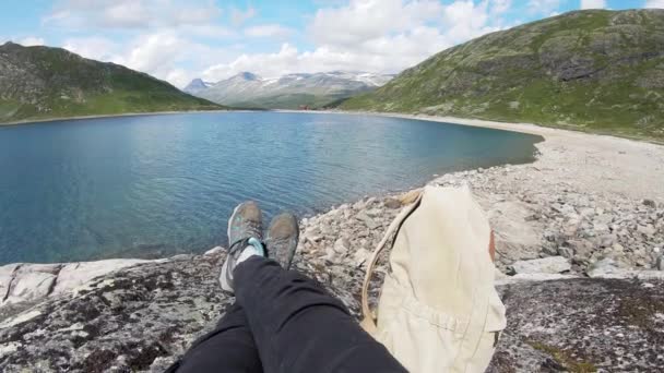 Egyedül üldögél a sziklán egy norvég fjord felett.. — Stock videók