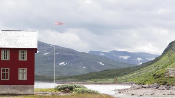 Typical Norwegian view with a rad house and Norwegian flag — Stock Video