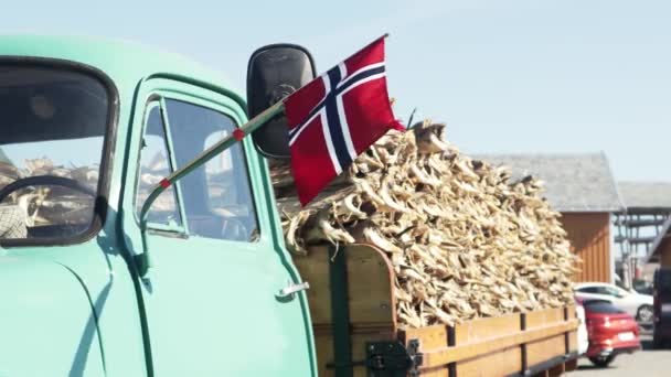 Norwegische Flagge auf dem Hintergrund eines mit getrocknetem Kabeljau beladenen Lastwagens — Stockvideo