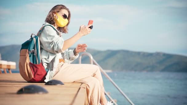 Jonge vrouwelijke reiziger doet selfie op een smartphone, nieuwe normale reizen — Stockvideo