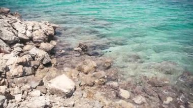 Deniz kıyısı, sahildeki beyaz kayalarda dalgalar yükseliyor. Turkuaz suyu temizle