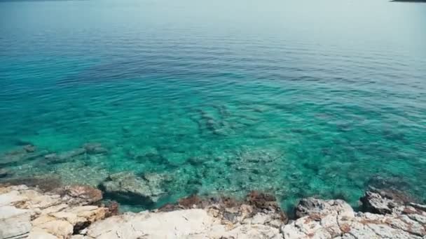 Průhledné tyrkysově modré moře, kamenné pobřeží. Krásná krajina — Stock video