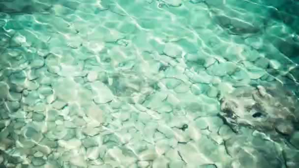 Şeffaf turkuaz mavi deniz suyu, üst manzara. Yüzeyde güneş parlıyor — Stok video