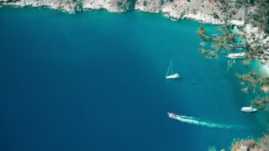 Kristal berrak mavi deniz ve teknelerin üst görüntüsü. Kelebek Vadisi, Türkiye.