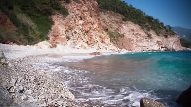 Imágenes cinematográficas de una hermosa playa vacía con olas azules cristalinas — Vídeos de Stock