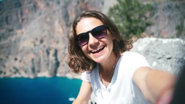 Une jeune femme en lunettes de soleil enregistre une vidéo de voyage pour un blog. — Video