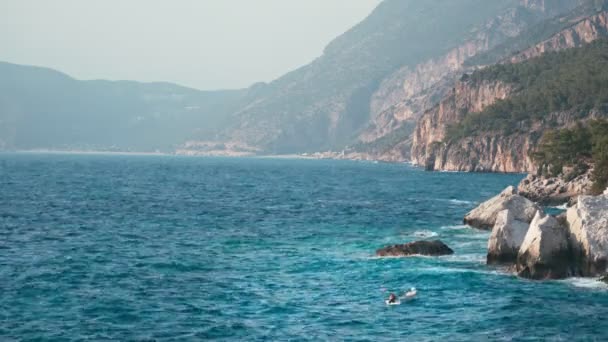 Vista do mar azul claro ondulado e à beira-mar rochoso — Vídeo de Stock