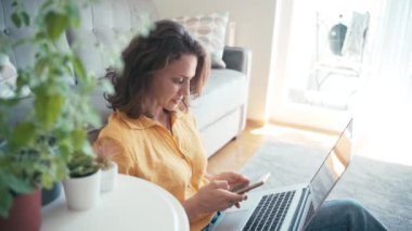 Evden çalışan neşeli, genç bir kadın..