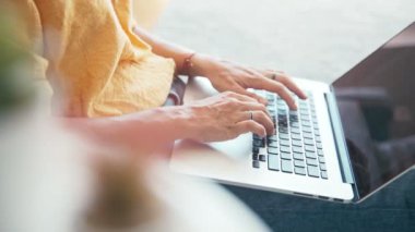 Dizüstü bilgisayarda yazı yazan bir kadının yakın çekim sineması..