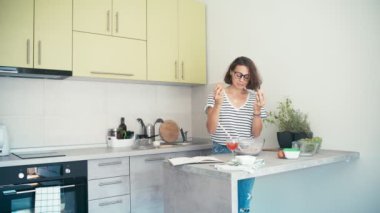 Genç, neşeli bir kadın blogcu, video bloğu için yemek videosu kaydediyor.