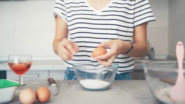 Cam bir kaseye bıçakla yumurta kıran bir kadının el kamerasıyla çekilmiş fotoğrafı. — Stok video