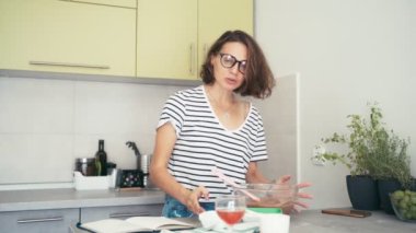 Genç, neşeli bir kadın blogcu, video bloğu için yemek videosu kaydediyor.