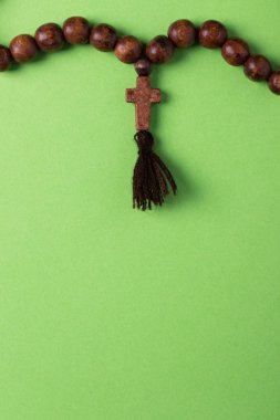 Ahşap tespih ve yeşil zemin üzerine çapraz.