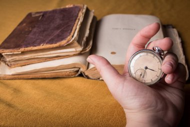 Eski püskü akıllıca kitap arka plan üzerinde çürüyen saat. 