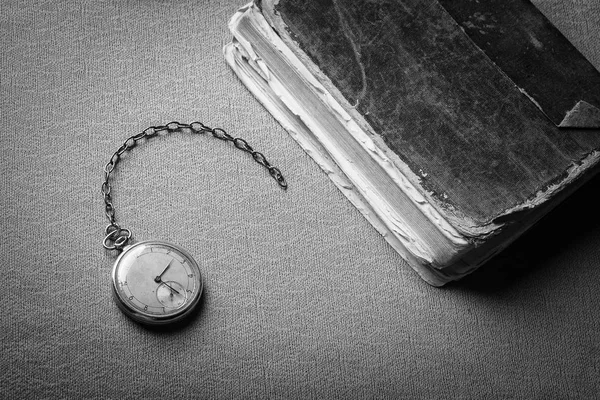 古いぼろぼろの賢明な本の背景に時計を減衰します 黒と白の写真 — ストック写真