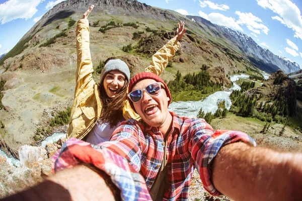 Man and female in hiking gear taking a selfie outside
