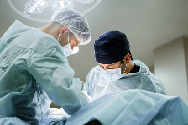 Two plastic surgeons perform an operation. Doctors are doing surgery.