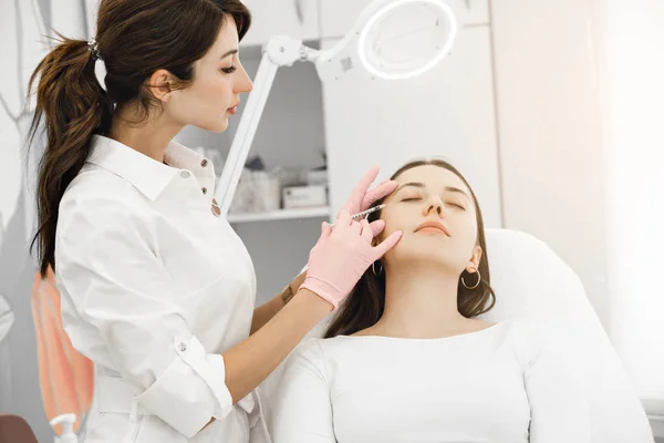 Genç kadın plastik cerrahi enjeksiyon yüzünde, closeup alma