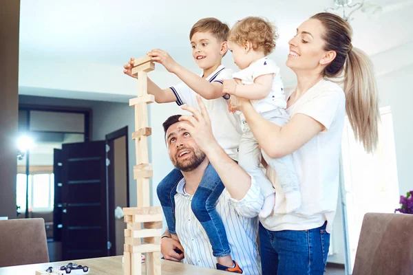 Een familie speelt bordspellen zitten aan een tafel binnenshuis. — Stockfoto