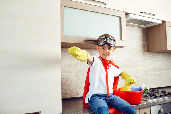 Um rapaz vestido de super-herói na cozinha — Fotografia de Stock