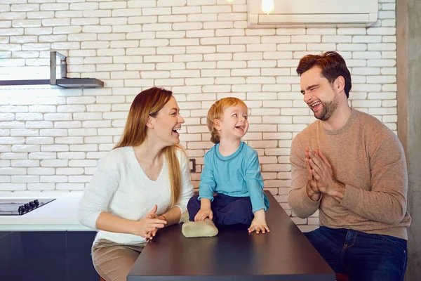 Een gelukkige familie speelt aan de tafel in de kamer. — Stockfoto