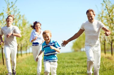 Baharda, bahçede yürüyüş mutlu aile eğleniyor yaz.