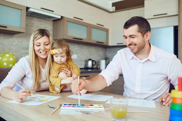 Matka, otec a dítě nakreslit společně u stolu. — Stock fotografie