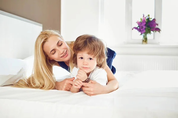 Mother plays with the baby on the bed. — Stock Photo, Image