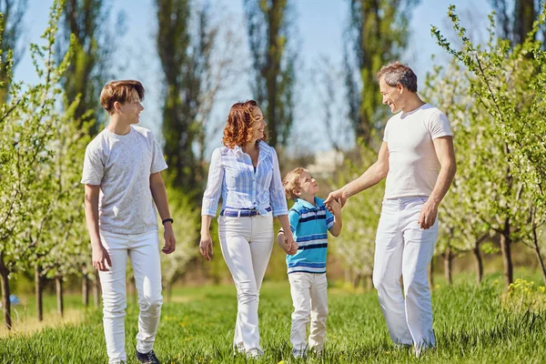 Una felice famiglia passeggia in giardino in primavera, in estate . — Foto Stock