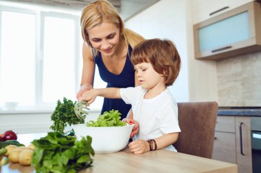 Anne ve çocuk mutfakta yiyecek hazırlama. 