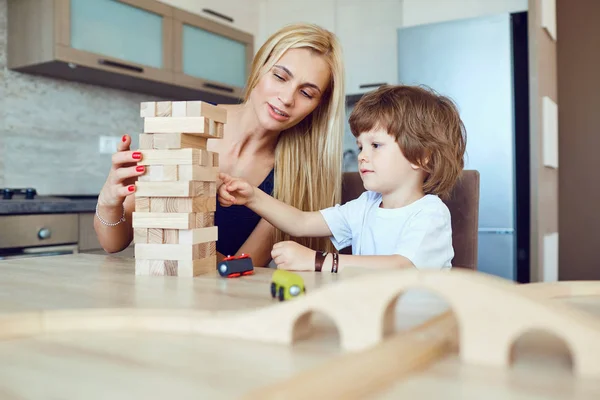 Mère et fils jouent à la table à l'intérieur — Photo