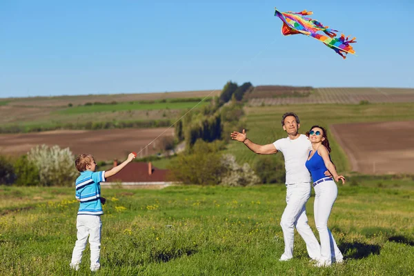 Doğa alanında oynayan bir uçurtma ile mutlu aile — Stok fotoğraf