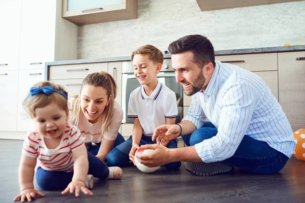 De familie speelt leuk op de verdieping binnenshuis — Stockfoto