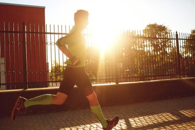 Sportif bir adam sokaklar boyunca çalışır.
