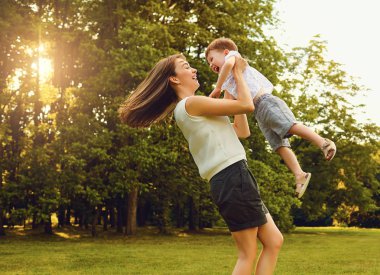 Gün batımında Parkta oynayan çocuk ile anne.